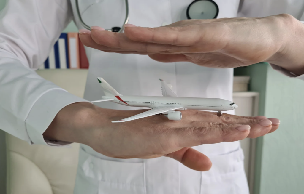 Medical person holding toy airplane in between their hands